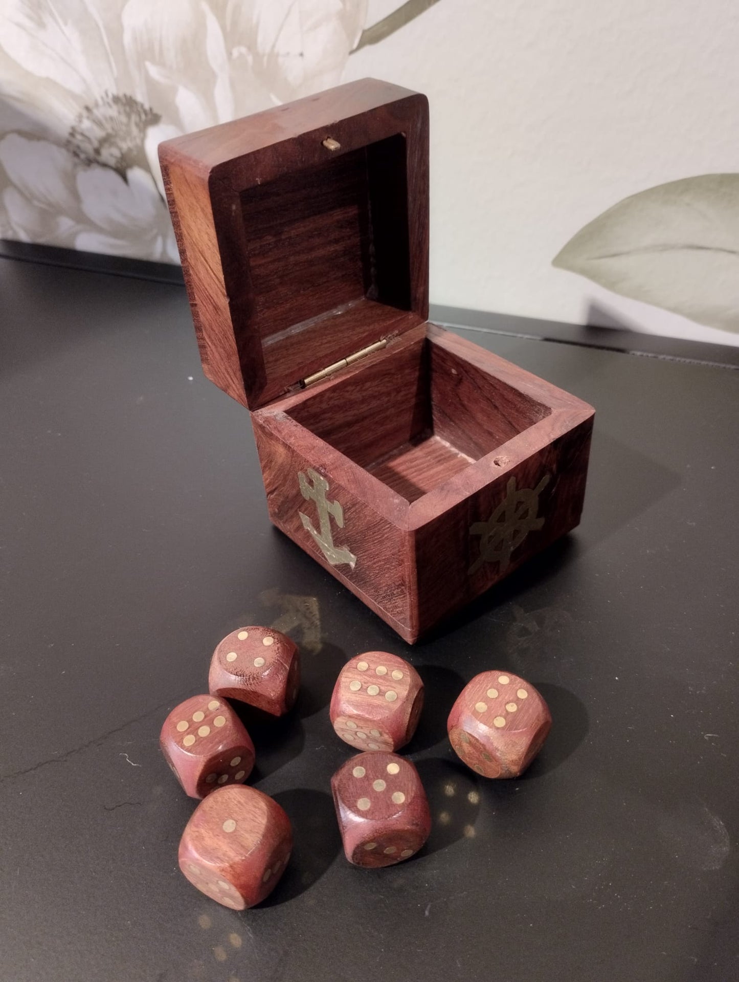 Fin, dekoartivt träask med nautisk motiv som innehåller 6 mindre tärningar för att spela t.ex. maxi yatzee. Material: trä, mässing Mått Träask: 7x7x7 cm Mått Tärningar: 2x2x2 cm
