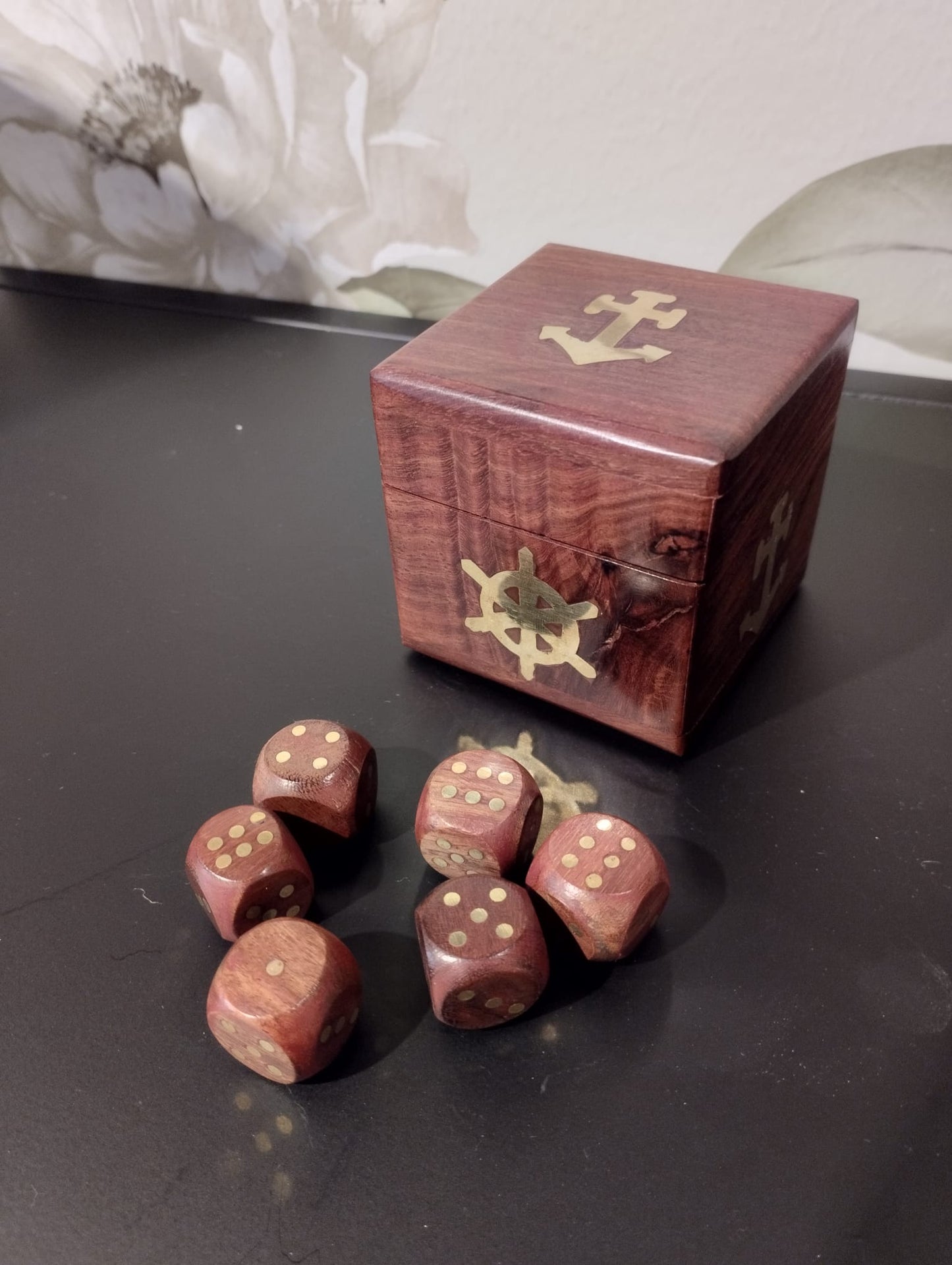 Fin, dekoartivt träask med nautisk motiv som innehåller 6 mindre tärningar för att spela t.ex. maxi yatzee. Material: trä, mässing Mått Träask: 7x7x7 cm Mått Tärningar: 2x2x2 cm