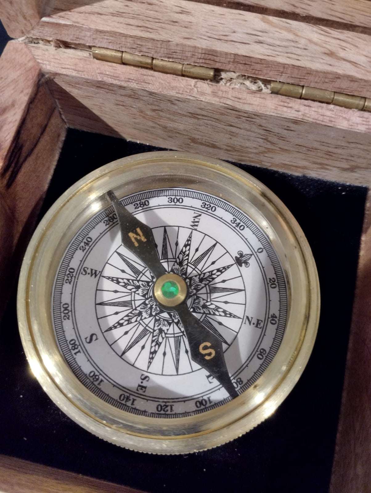 Kompass i elegant trälåda.  Mått Trälåda: 9x9cm, H4,5cm  Mått: Kompass: Diameter 6cm, H 2cm  Material: Trä, Metall, Glas