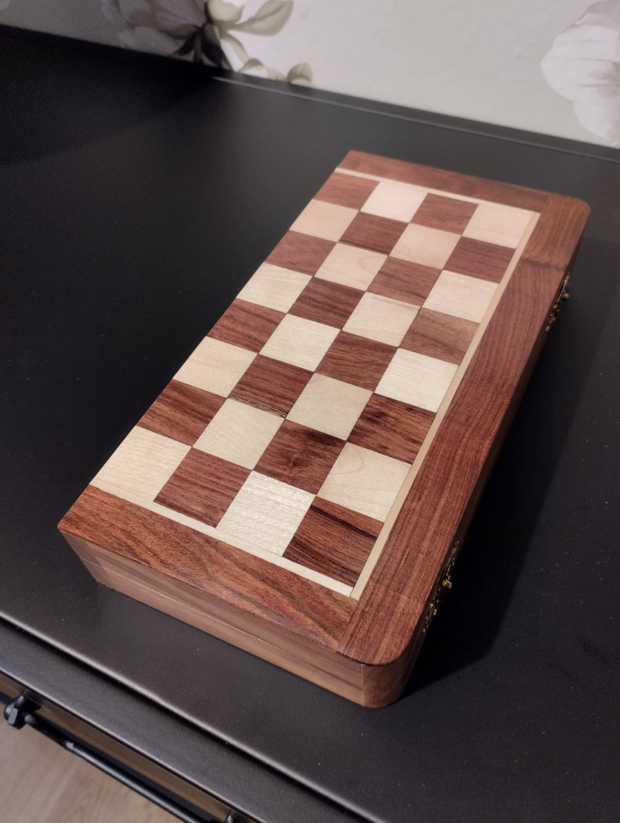Schackbräde i trä med pjäser i brunt och vitt. Schackbrädet består av ett rutmönster med 64 omväxlande ljusa och mörka rutor. När du spelat klart fäller du ihop brädet som då bildar en låda där du förvarar pjäserna. Perfekt att ta med på resan eller förvara i bokhyllan.