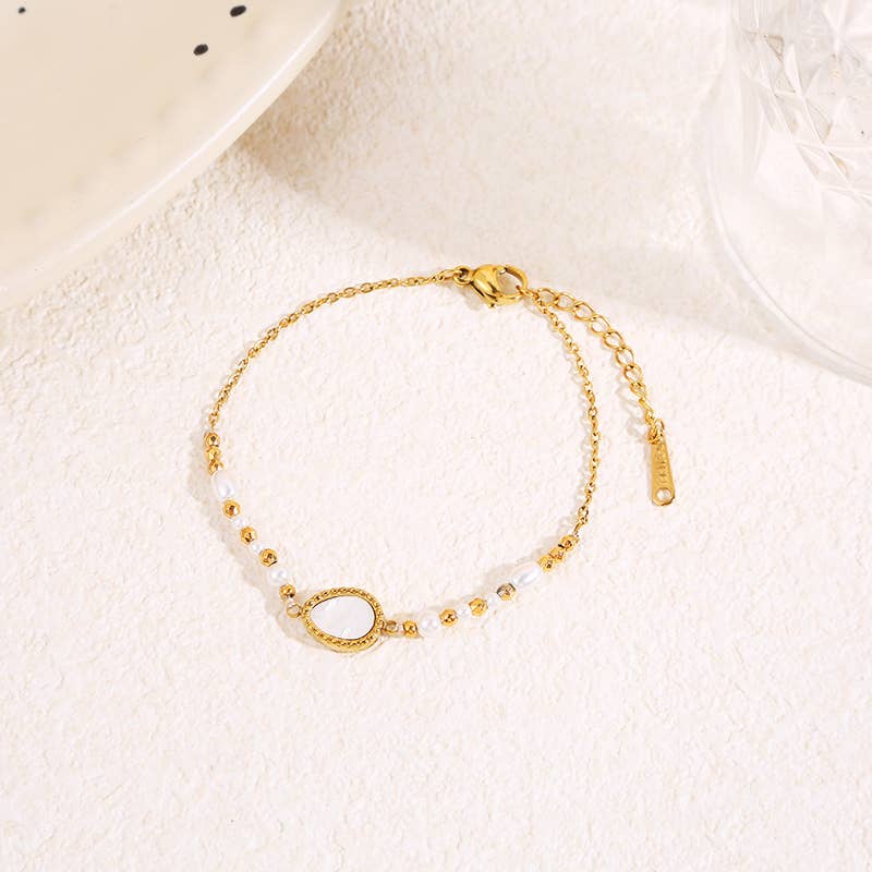 Gyllene armband med pärlemorsdroppe