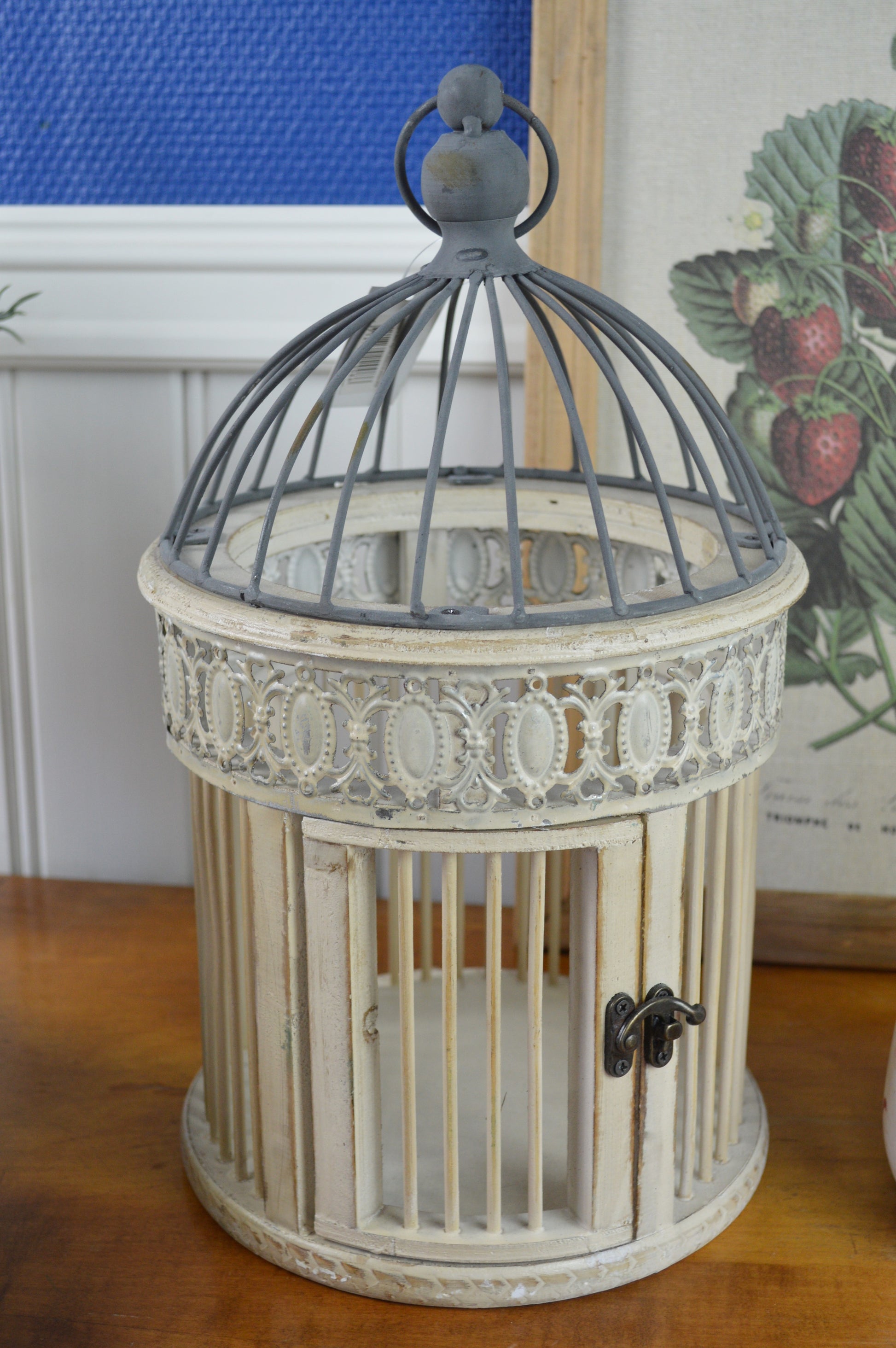 En vacker fågelbur med dekorativ metallkant i en romantisk vintage stil.  Mått: H35,5/Ø20,5 cm  Material: Metall, fanér, bambu