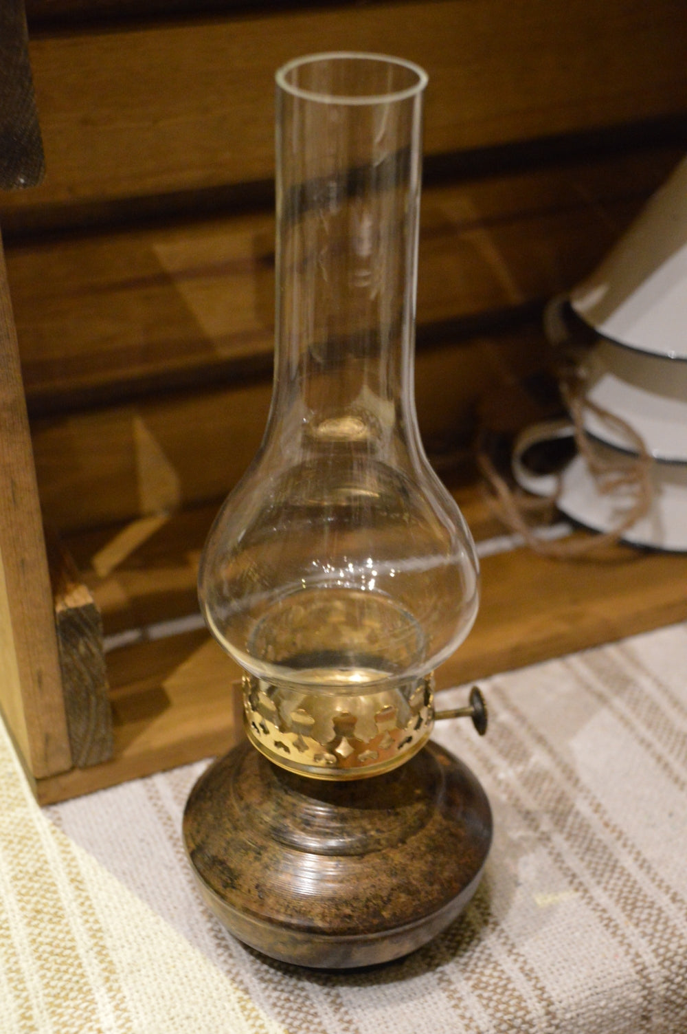 Lampa för värmeljus: Värmeljuslykta med utseendet av en gammal fotogenlampa med fot i antikmässing och glaskupa som skyddar lågan.  Mått: H 27cm   B 10cm  Till Värmeljus. Ingår ej.  Material: Emalj, Metall & Glas