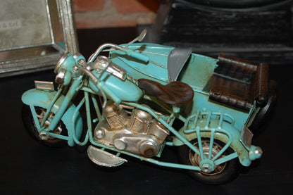 Vem kan motstå den coola motorcykeln med sidovagn? Perfekt present till den motortokiga.  Mått: H11cm x B14,5cm x L18,5 cm  Material: Metall/Plåt  Färg: ljusblå  OBS: Dekoration, ingen leksak.